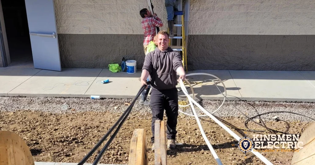 Workers installing high-voltage electrical systems by pulling cables on dowels to a commercial property, part of Kinsmen Electric’s commercial electrical installation.