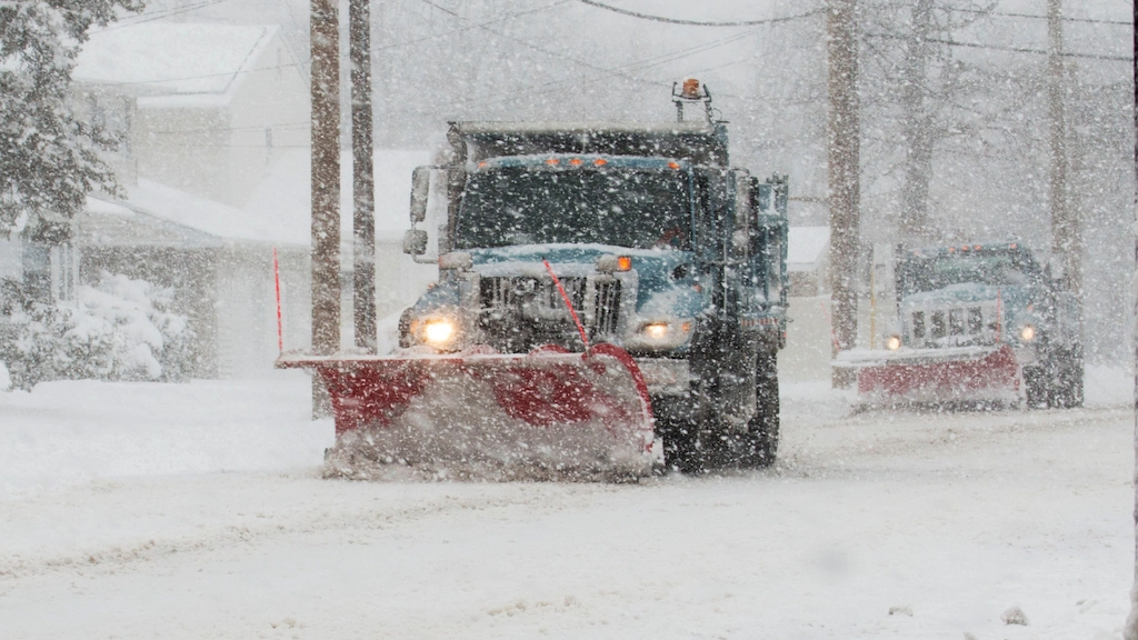 snow plows clear a snow-covered street in a Pennsylvania town during a winter snowstorm