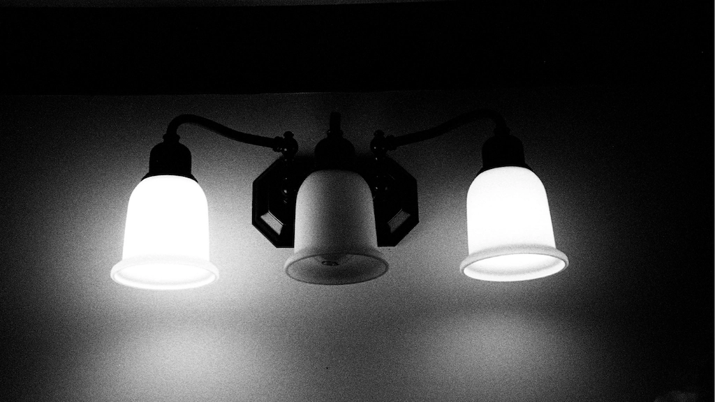 a light fixture featuring three lights. The middle bulb is burnt out