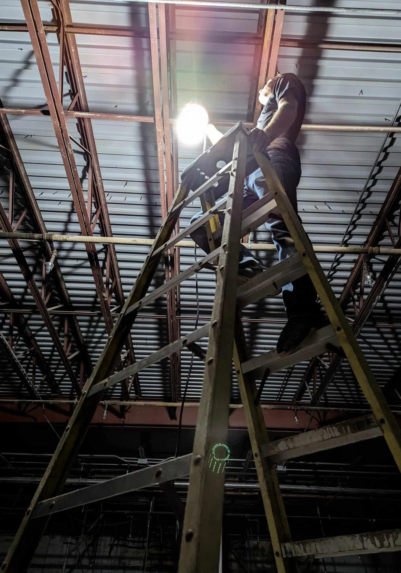 man on ladder installing lights